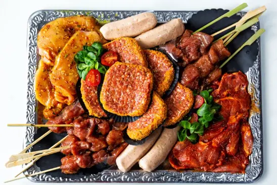Barbecueschotel met satéspiesen, karbonade, speklap, barbecueworst, hamburger en kipfilet.